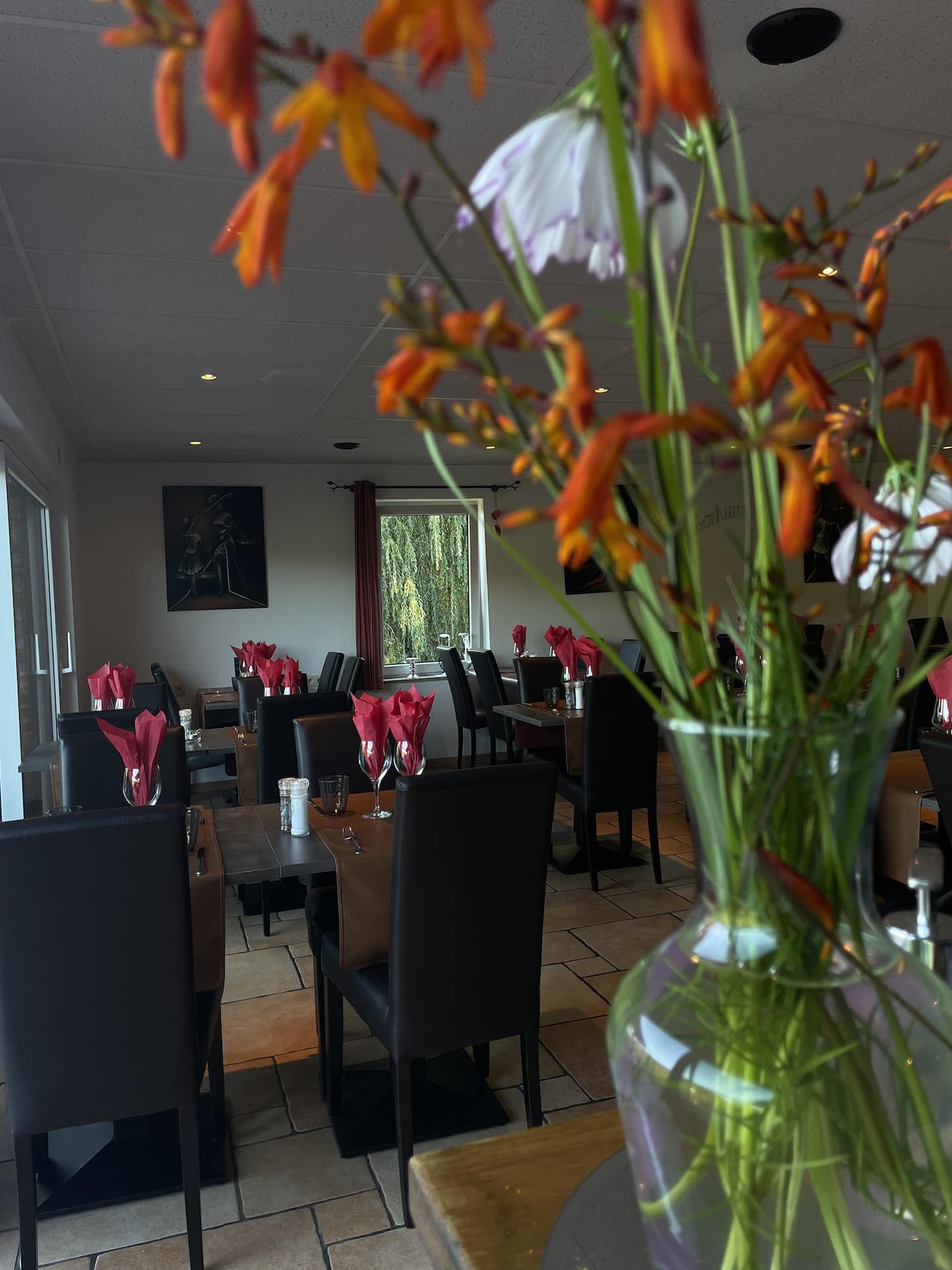 Intérieur de restaurant élégant avec fleurs en premier plan.